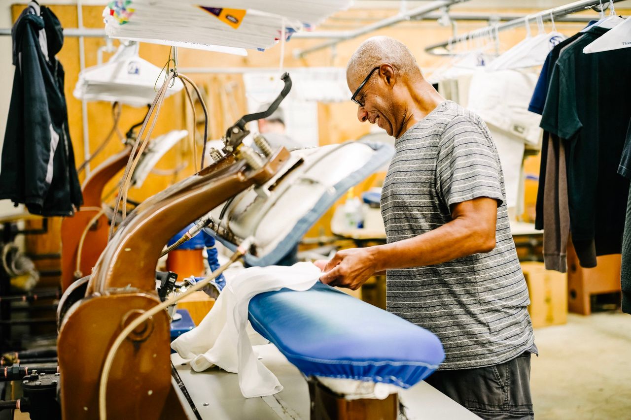 A presser finishing a garment at Washing Dynasty