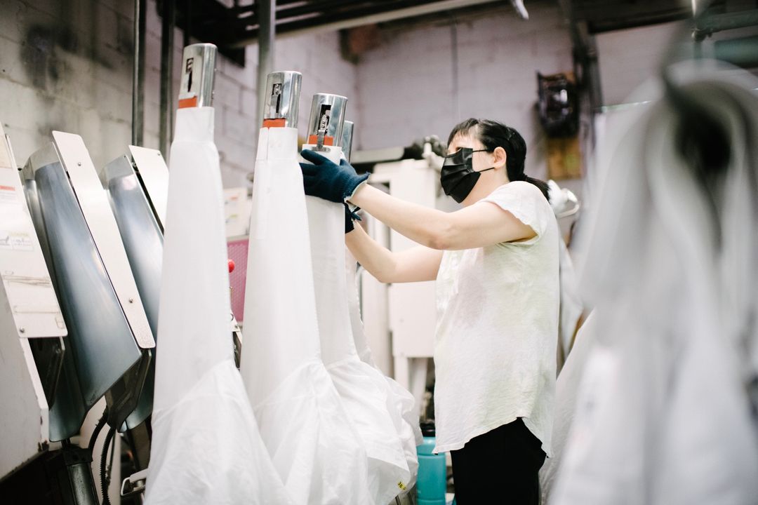A Washing Dynasty team member finishing garments on the production floor